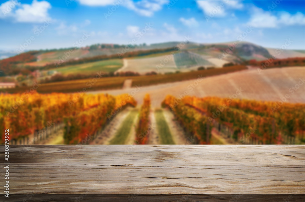 Brown wood table in autumn vineyard landscape with empty copy space on the table for product display