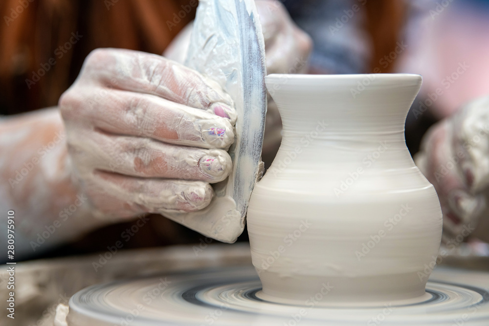 Potter makes pottery dishes on potters wheel