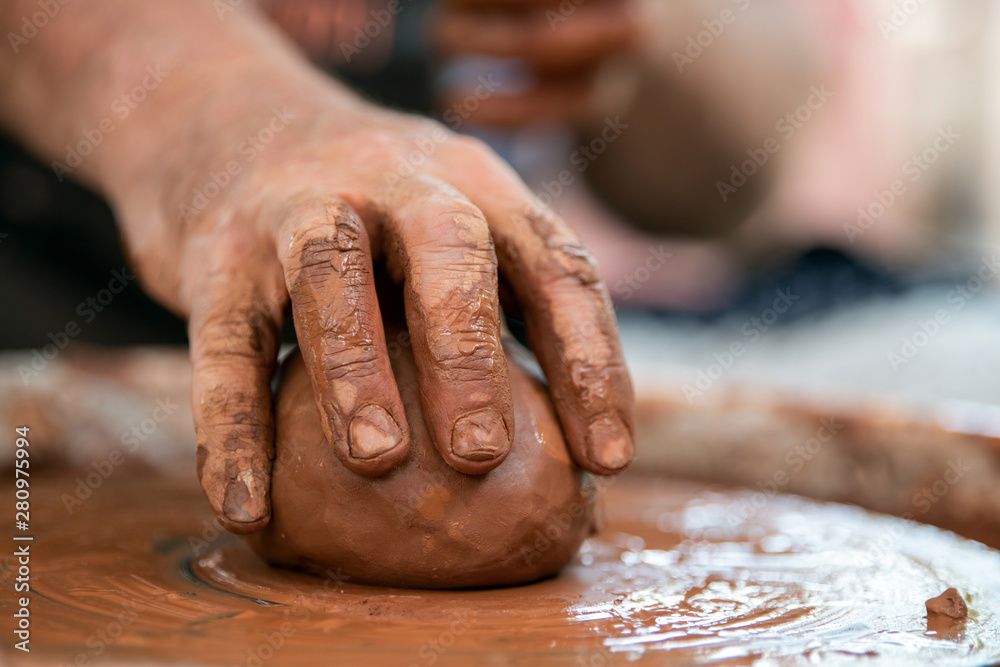 Potter makes pottery dishes on potters wheel