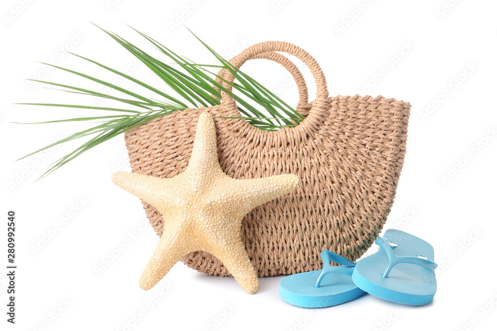 Beach bag, flip-flops and starfish on white background