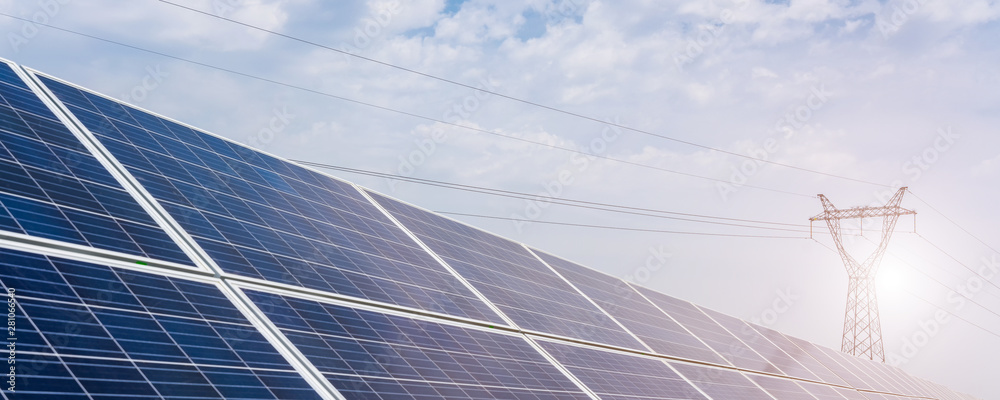 A row of solar photovoltaic panels under a blue sky