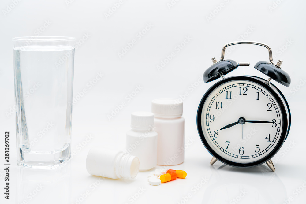 Pills, capsules, bottles and alarm clock