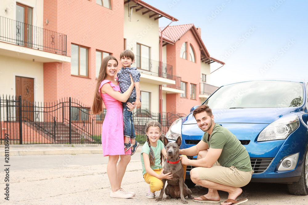 Happy family with dog near car outdoors