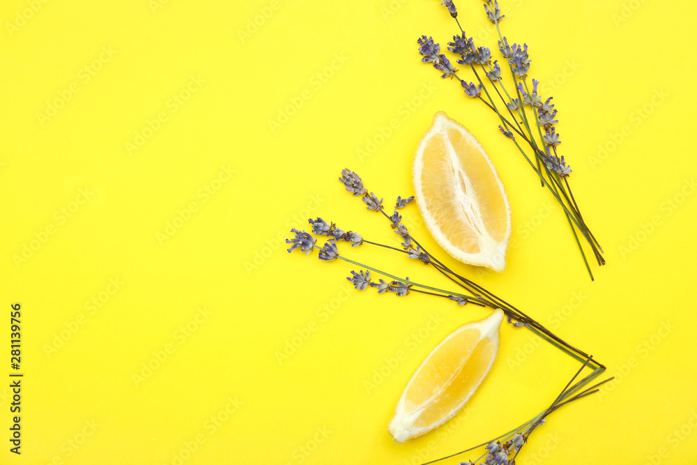 Beautiful lavender flowers with lemon pieces on color background