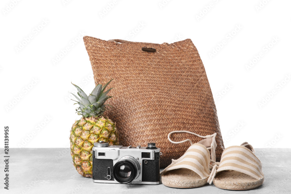 Beach bag and accessories on table against white background