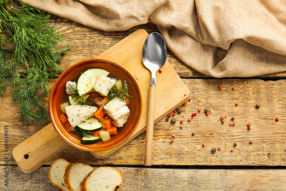 Bowl of tasty soup on wooden table