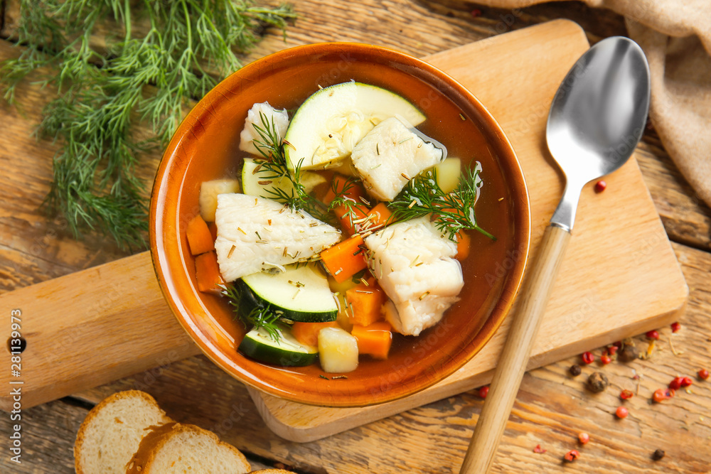 Bowl of tasty soup on wooden table