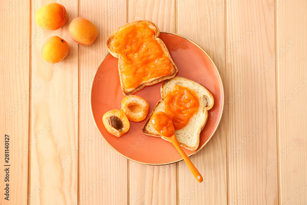 Plate with tasty bread slices and jam on wooden table