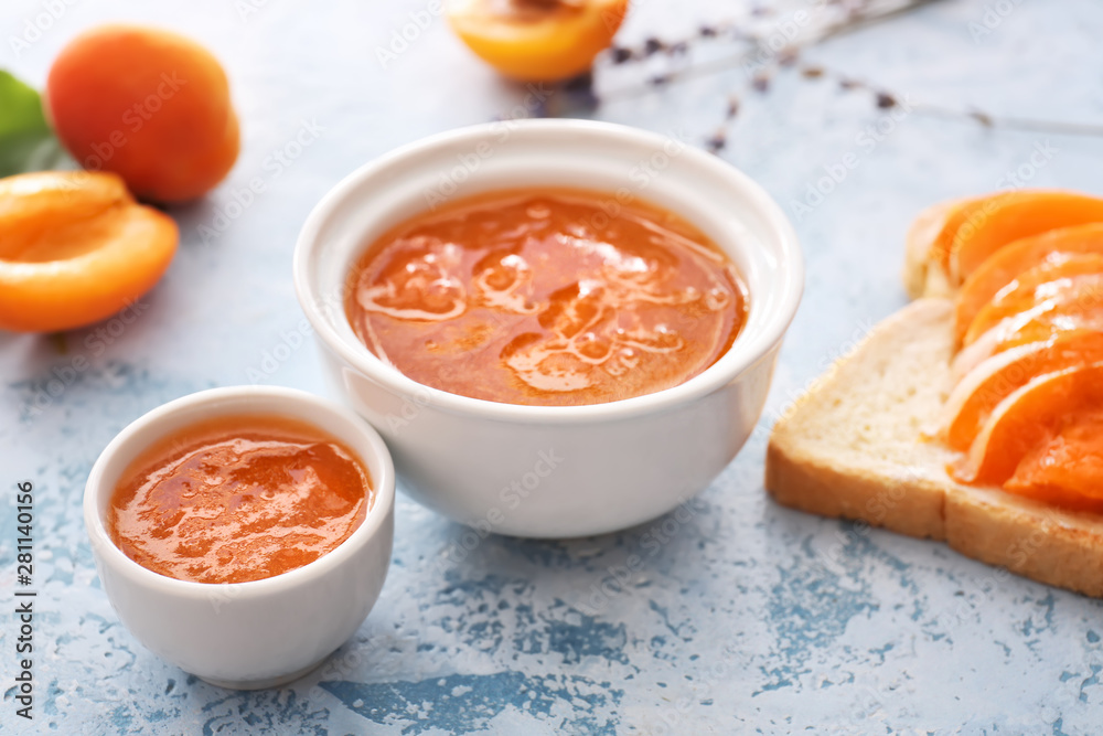 Bowls of tasty apricot jam on table