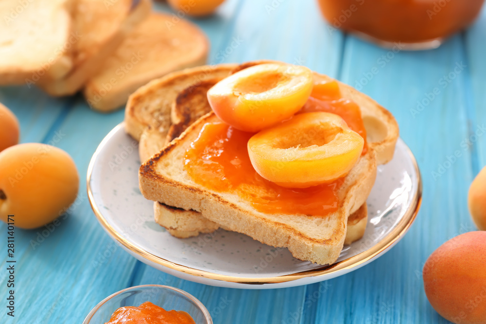 Bread slices of tasty apricot jam on wooden table