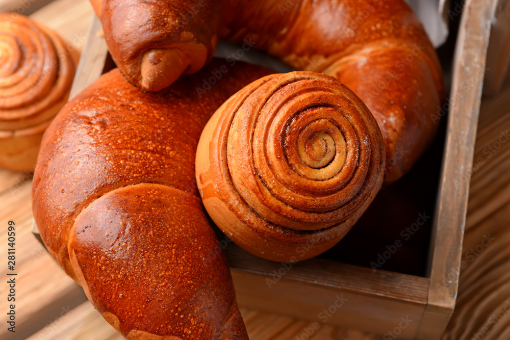 Basket with tasty pastries on wooden background, closeup