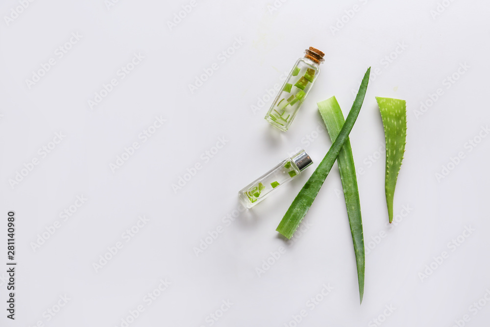 Fresh aloe leaves with essential oil on white background