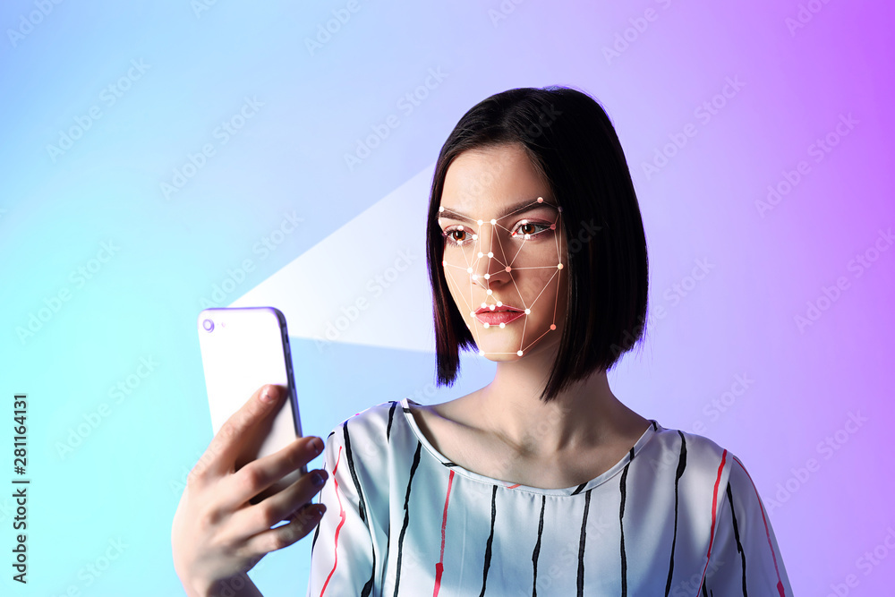 Portrait of young woman with mobile phone on color background