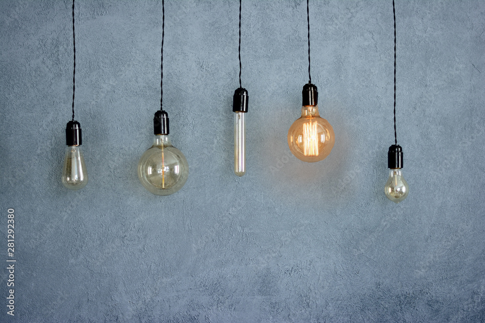 set of  light bulbs on grey background isolated, one glowing