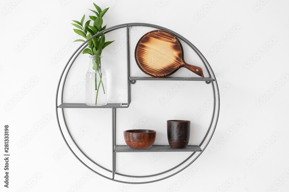 Stylish shelf with kitchen utensils on white wall