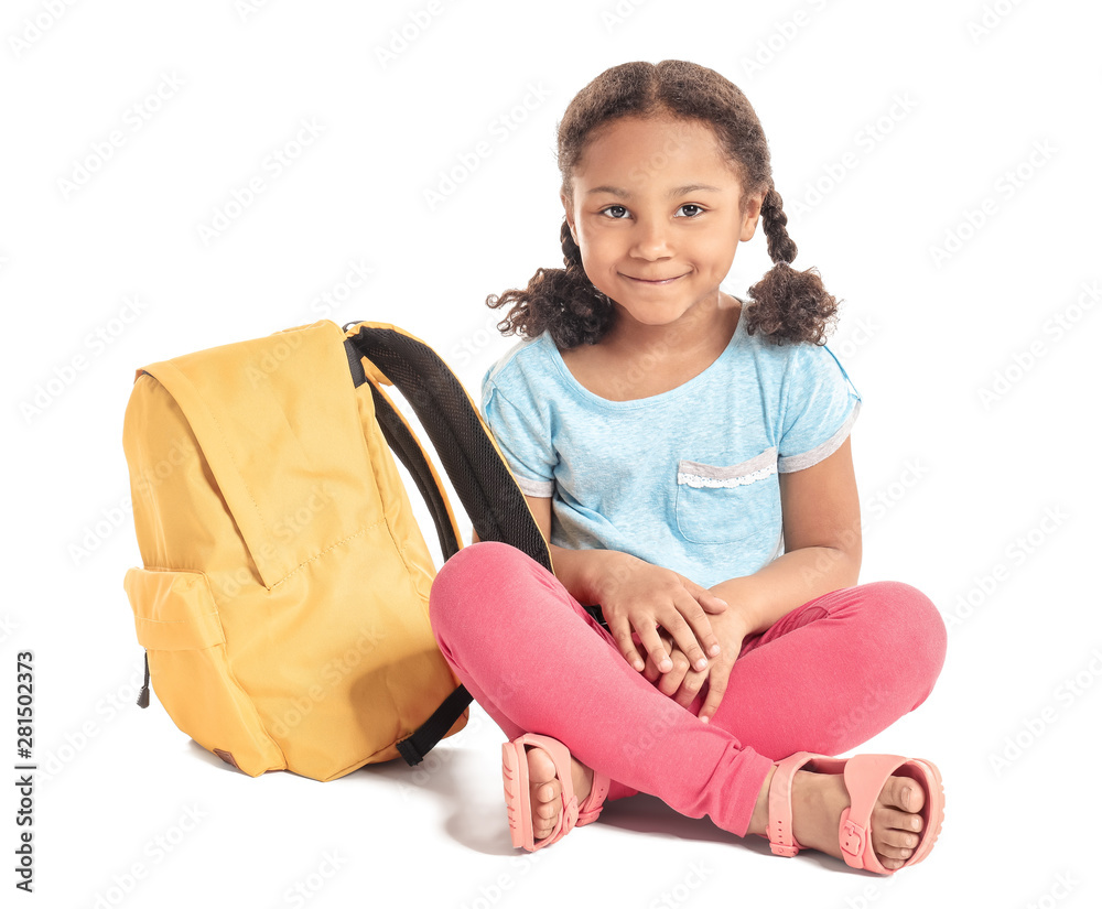 Adorable little African-American schoolgirl on white background