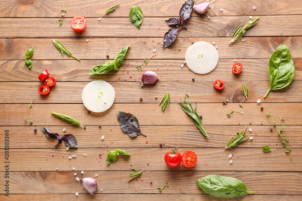 Fresh herbs with vegetables and spices on wooden background