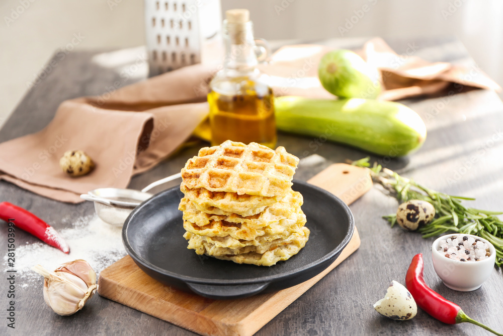 Frying pan with tasty squash waffles on grey table