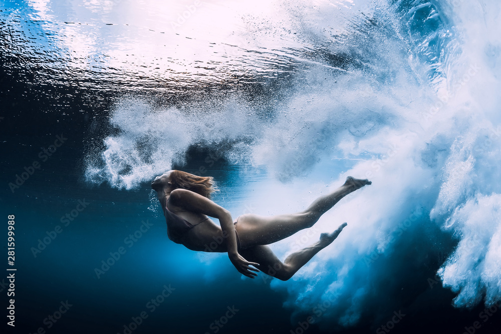 女人在大海浪下游泳。