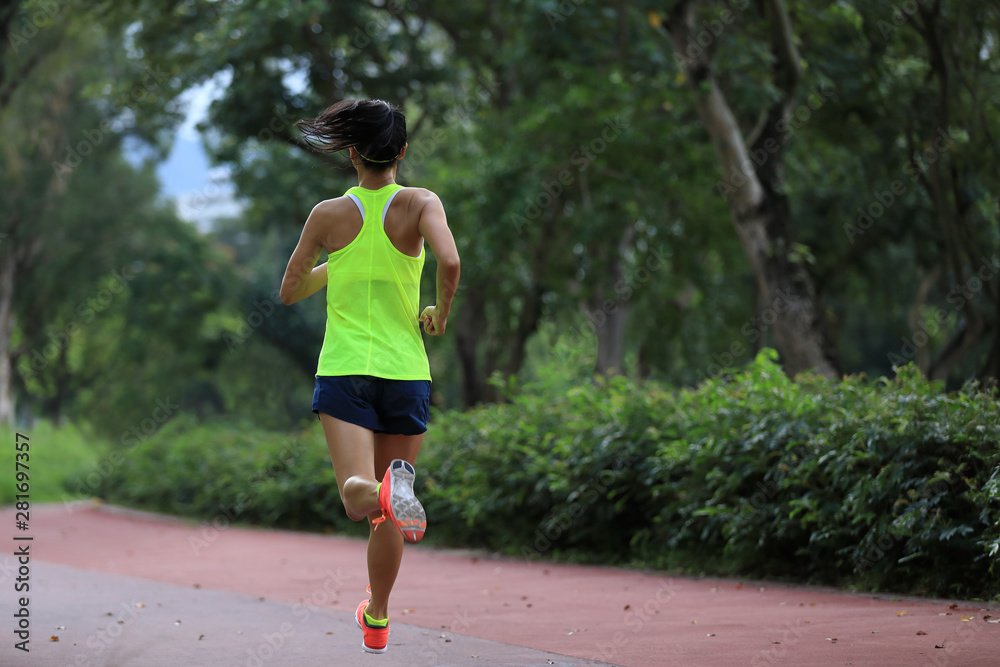 Fitness sporty woman jogger running at outdoors jogging track in park