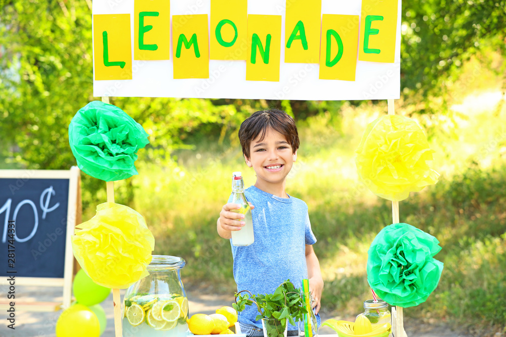 Cute little boy at lemonade stand in park