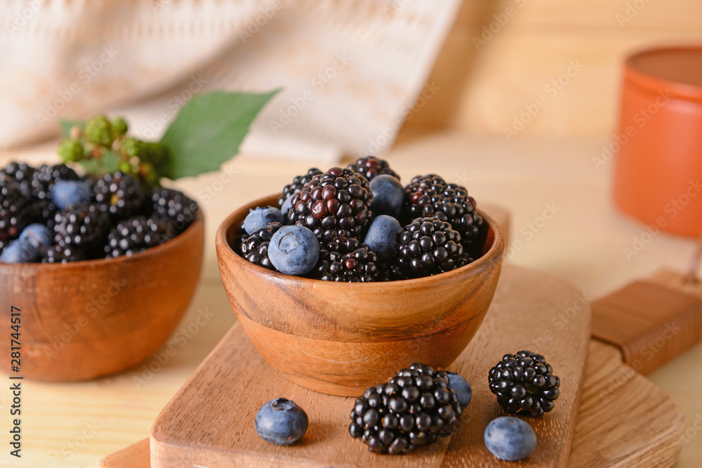 Tasty blackberries and blueberries on table