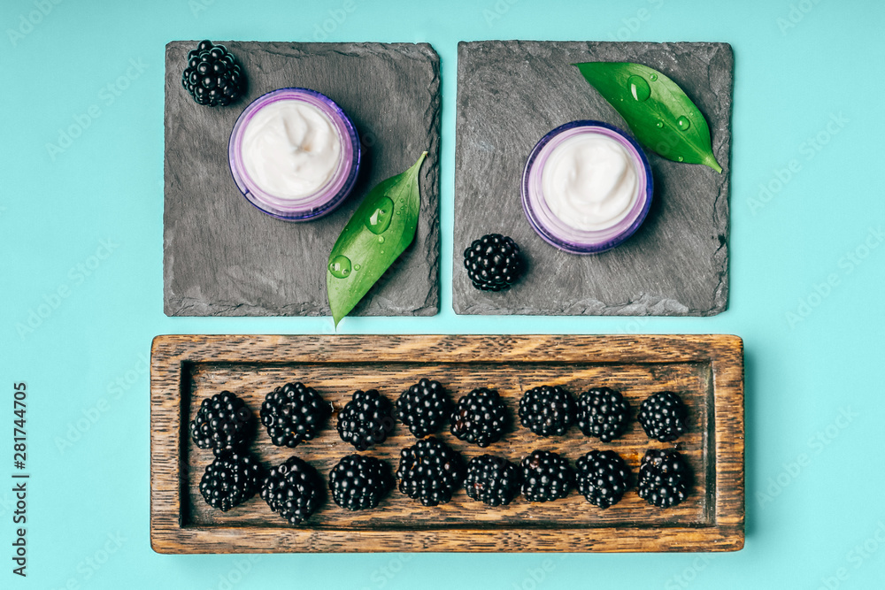 Composition with natural cream and blackberry on color background