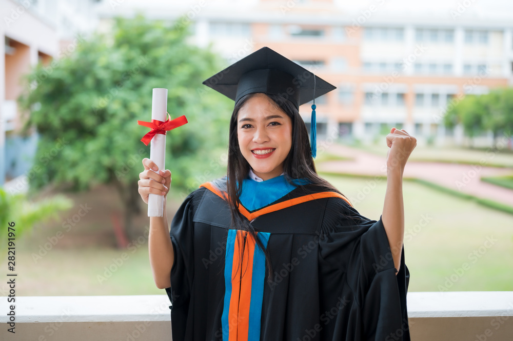 女性肖像，大学毕业生穿着黑色褶皱连衣裙，戴着黑色帽子，戴着蓝色流苏。