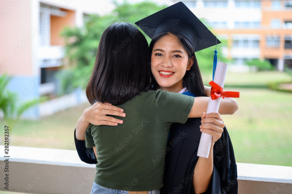 大学毕业生穿着黑色褶边连衣裙、黑色帽子和蓝色流苏的女性肖像。