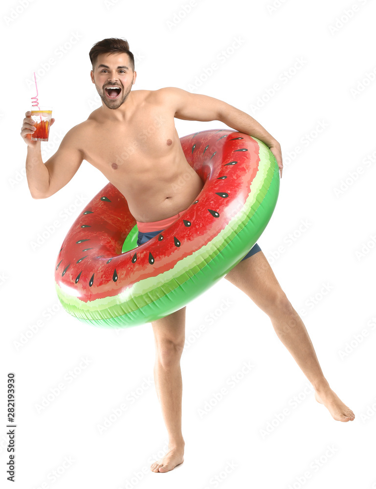 Handsome young man with inflatable ring and cocktail on white background