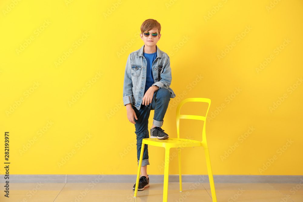 Stylish boy in jeans clothes near color wall