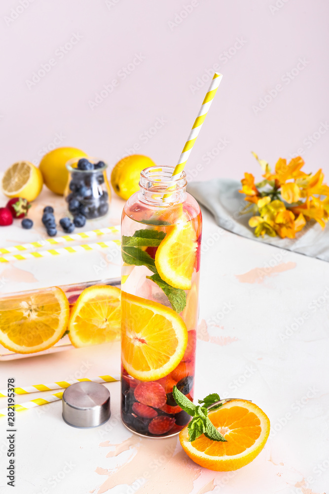 Bottle of tasty infused water on light table