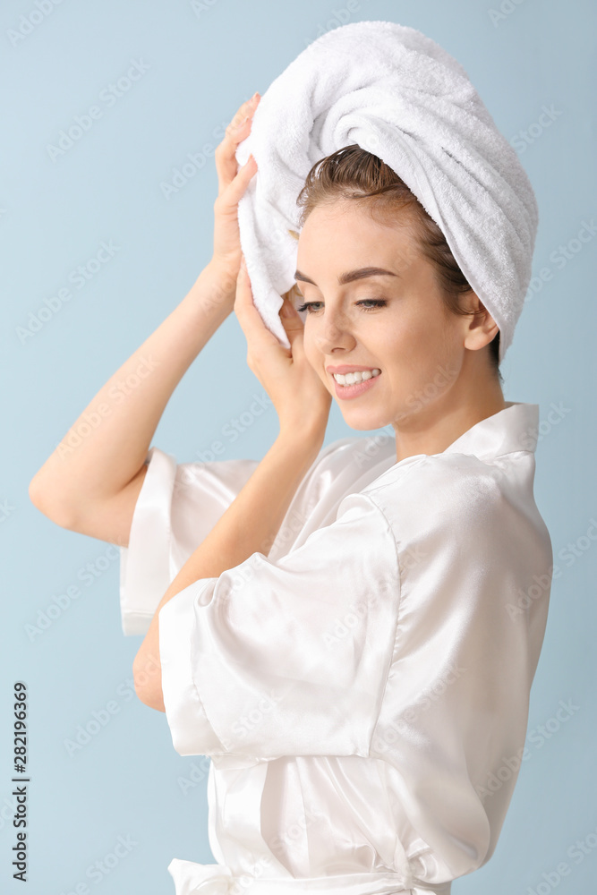 Beautiful young woman after washing hair against color background