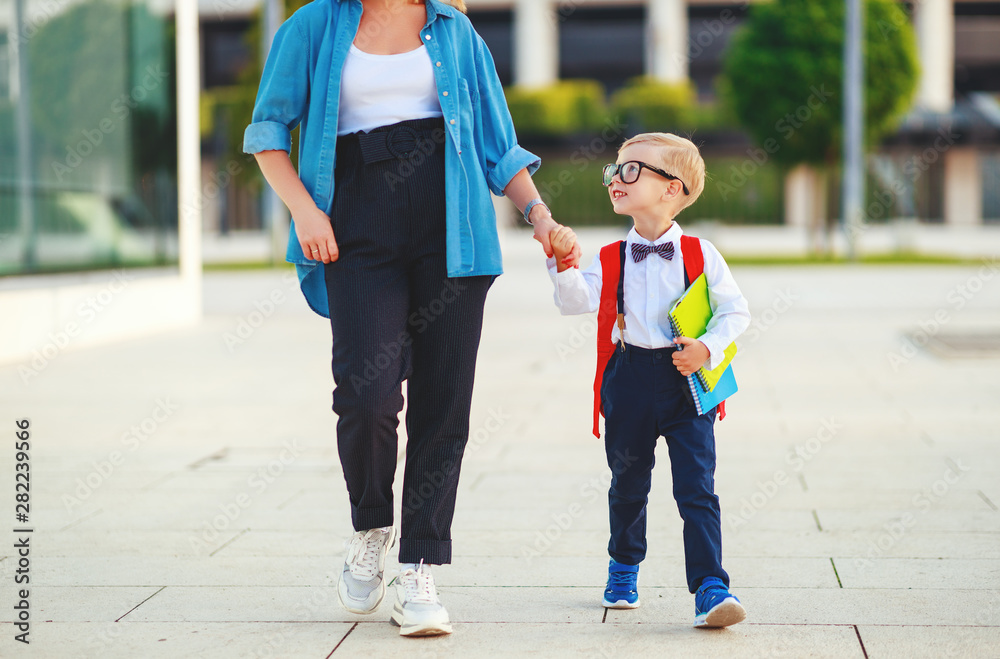 first day at school. mother leads  little child school boy in first grade