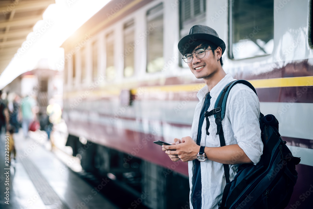 亚洲人是旅行者，他在等他们的火车。户外冒险旅行的火车概念。禁止