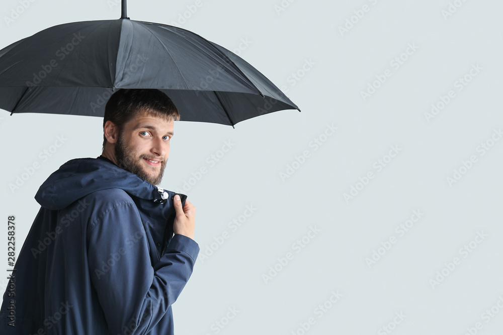 Handsome man with umbrella on white background