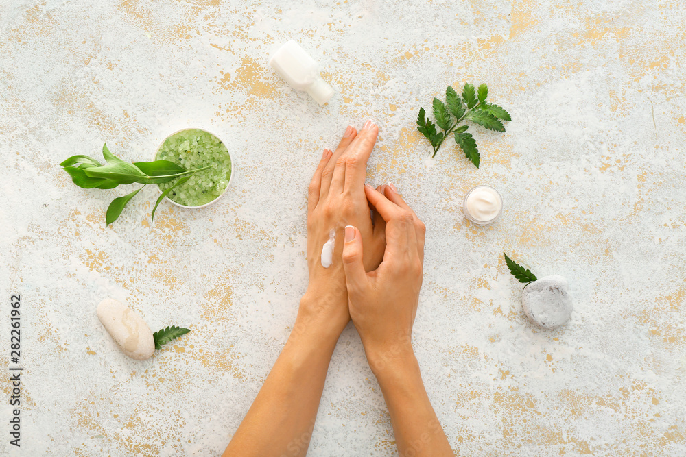 Female hands with natural cream on light background