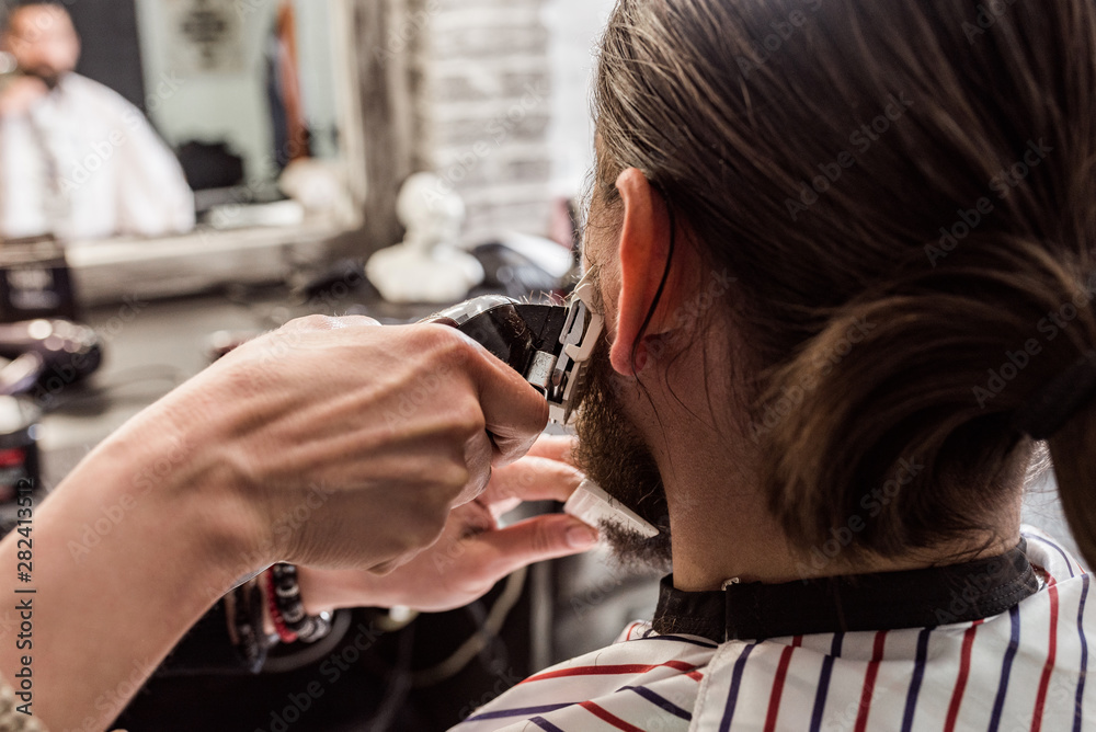 Rear view of bearded man at barbershop.