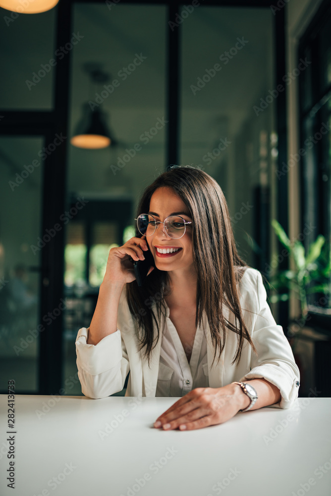 微笑的年轻女商人在手机上聊天的肖像