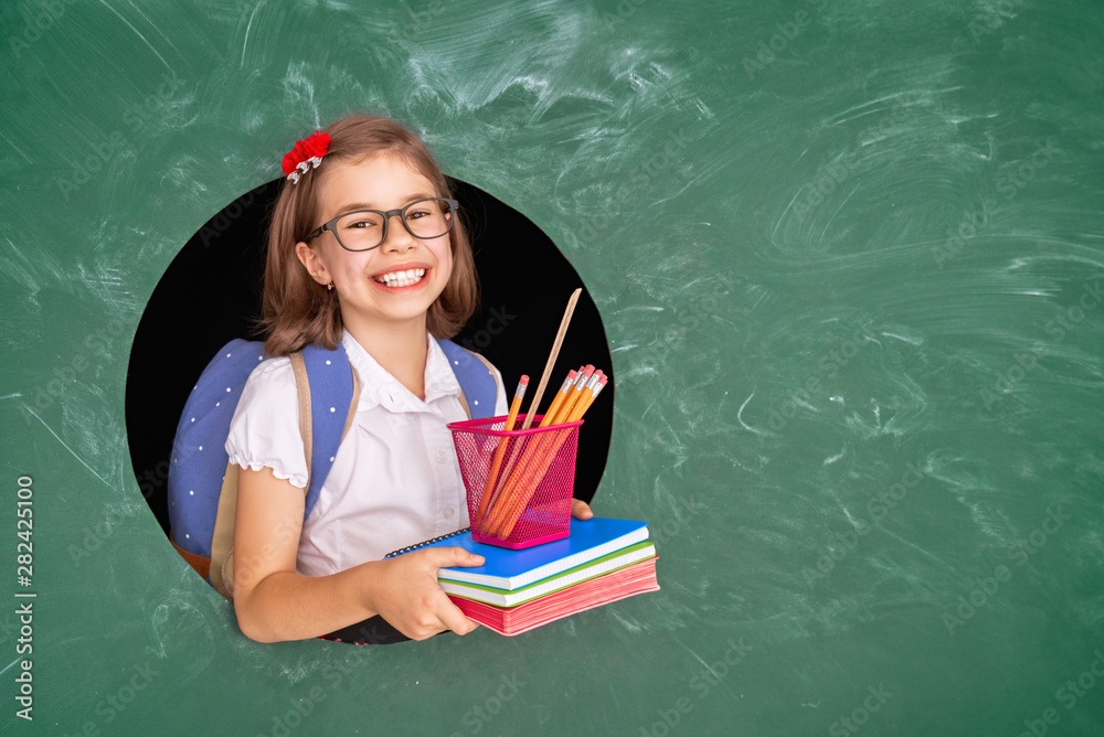 Kid in class on background of blackboard.