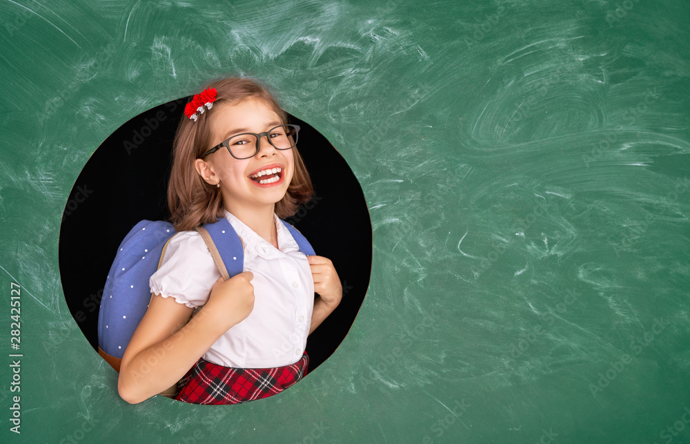 Kid in class on background of chalkboard.