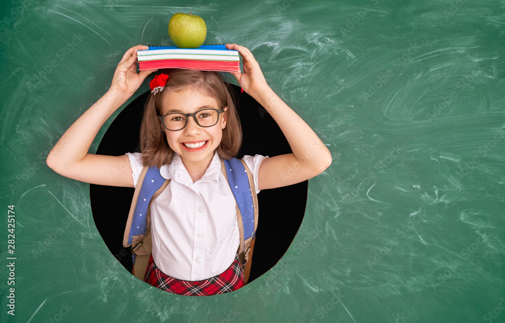 Kid in class on background of chalkboard.