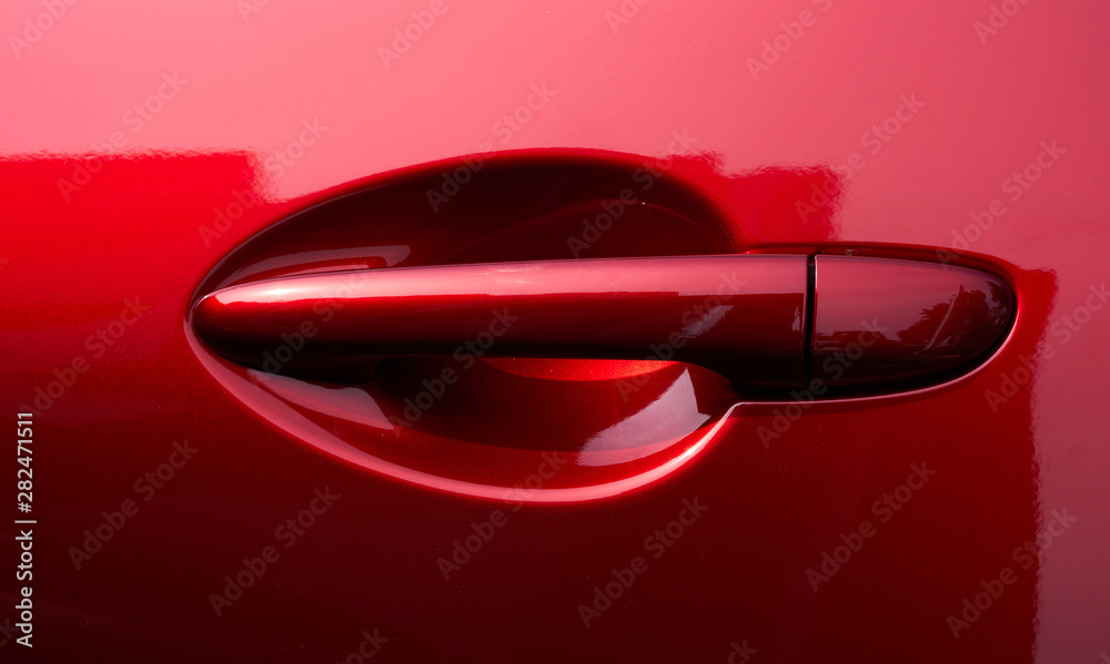 Close up of the door handle of a red car