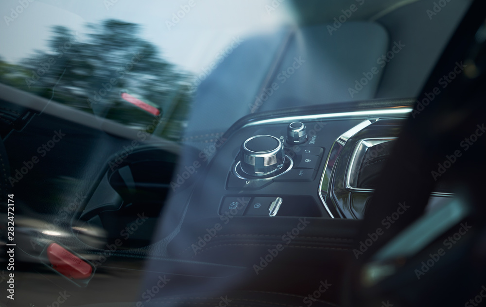 Vehicle interior of a modern car with media and navigation control buttons,looking through car windo