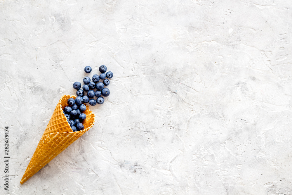 Summer breakfast with fresh berries in waffle cones on light stone background top view mockup