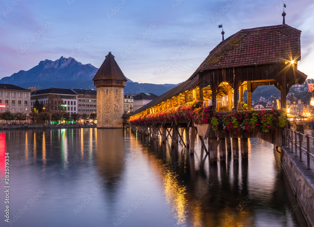 Old wooden architecture called Chapel Bridge in Luzern or Lucerne, Switzerland during sunset and twi