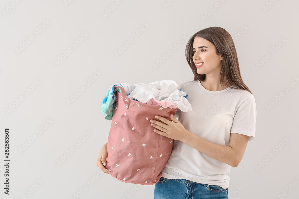 漂亮的年轻女子，浅色背景下洗衣服