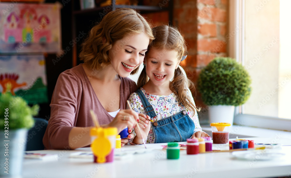 mother and child daughter painting draws in creativity in kindergarten.