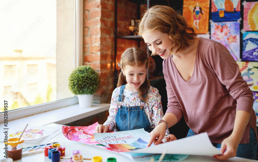 mother and child daughter painting draws in creativity in kindergarten.