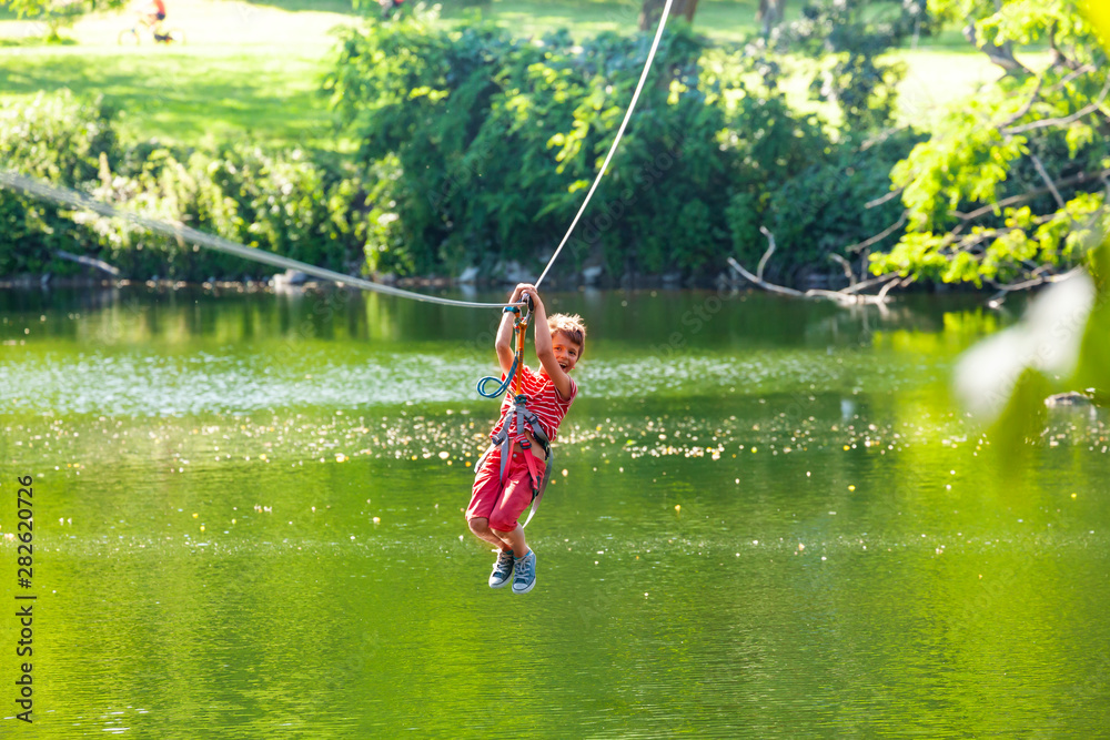 Happy child slide zip line with trolley over lake